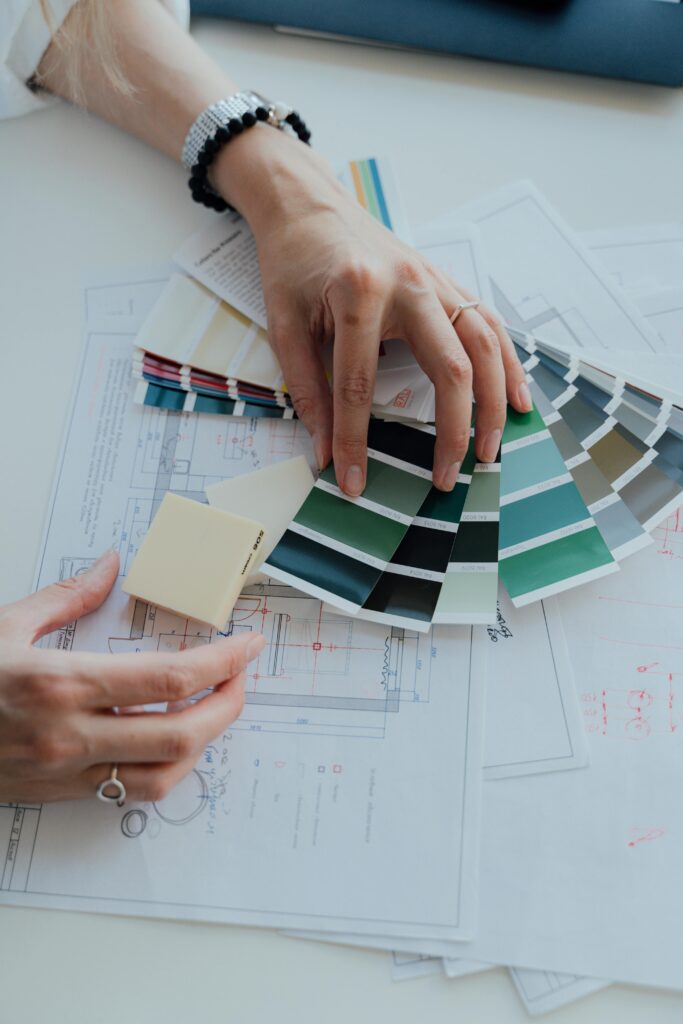 Interior designer evaluating color swatches and blueprints in the workspace.